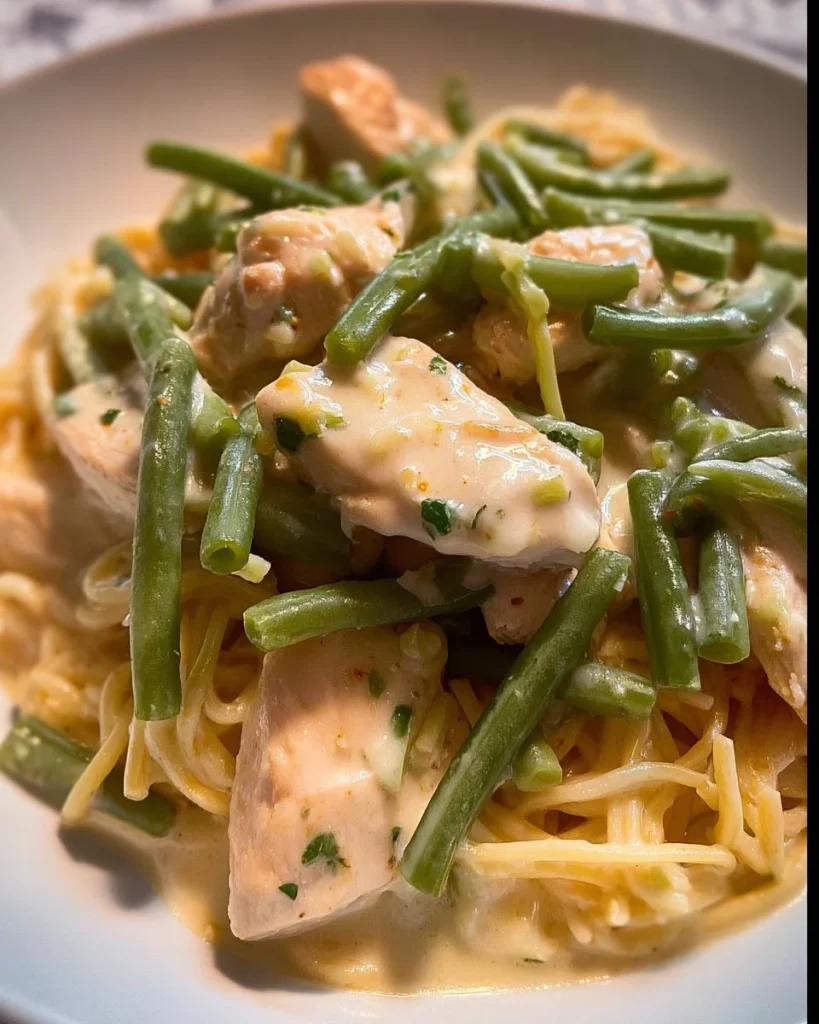 Hähnchenpfanne mit grünen Bohnen und Spaghetti serviert auf einem Teller