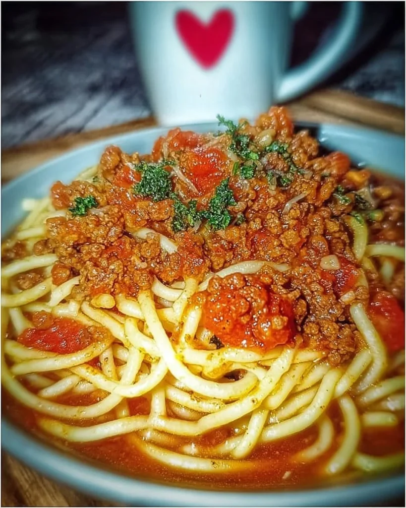Ein Teller Spaghetti Bolognese mit frischen Kräutern und Parmesankäse