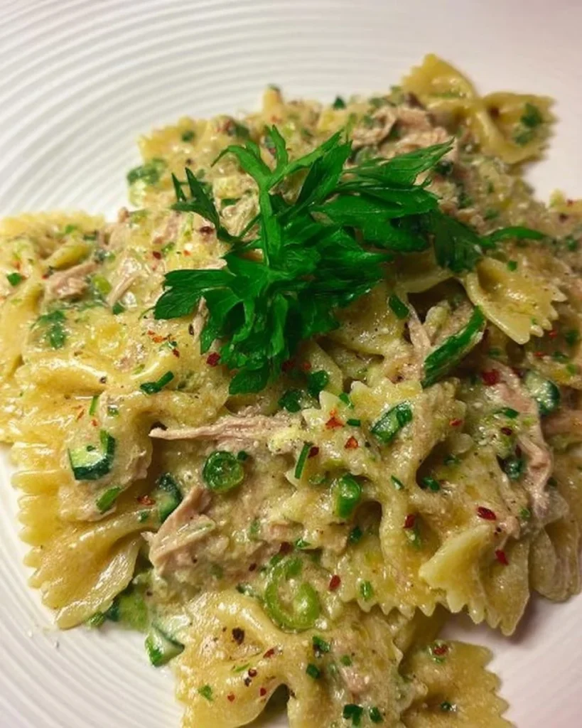Farfalle mit Zucchini-Sahne und Thunfisch auf einem Teller serviert