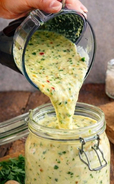 Hausgemachte Knoblauchcreme in einer weißen Schüssel auf einem Holztisch