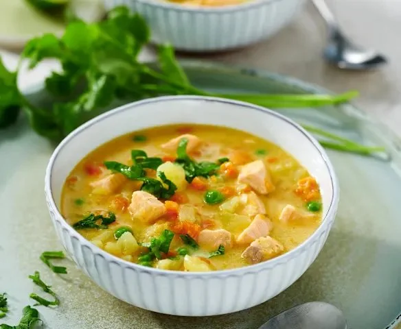 Köstliche Kartoffel-Kokos-Suppe mit Lachs serviert in einer schönen Schale