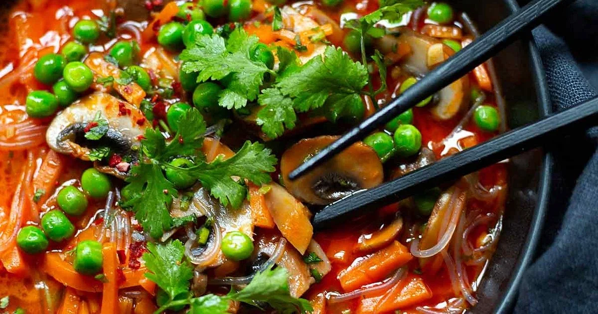 Schüssel thailändische Gemüsesuppe mit Kokosnussmilch und frischen Kräutern