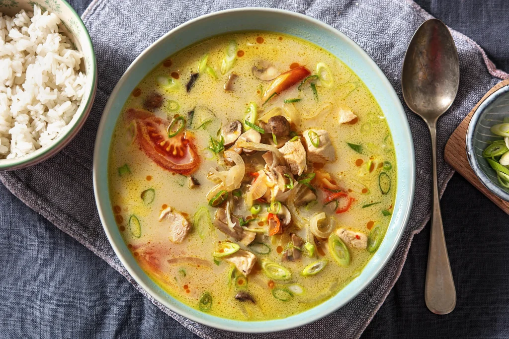 Schüssel mit Tom Kha Gai, thailändischer Kokosnuss-Hühnchensuppe.