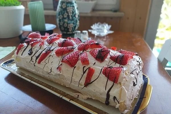 Biskuitrolle mit Erdbeerfüllung auf einem Teller