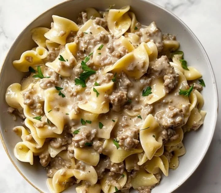 Cremige Hackfleisch-Pasta mit Schleifennudeln auf einem Teller serviert.