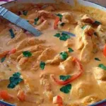 Delikates Hähnchen Stroganoff serviert mit Beilagen auf einem Teller