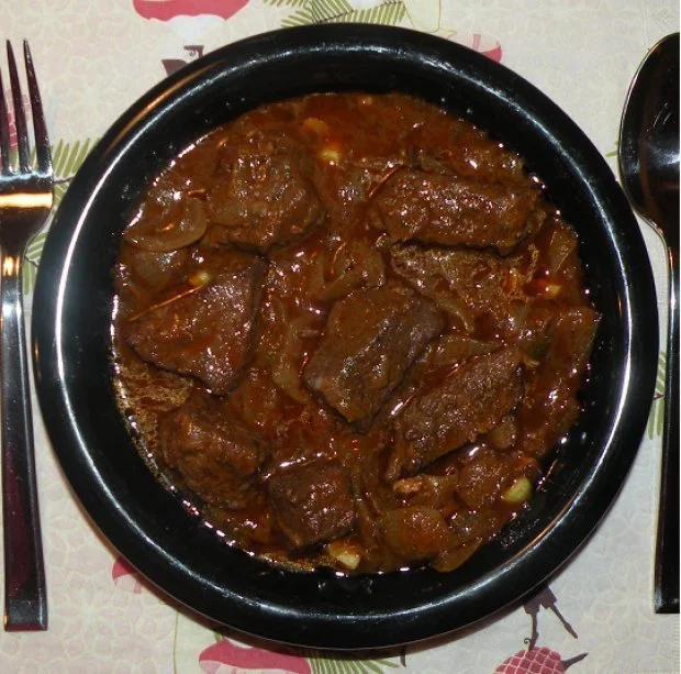 Hirschragout mit frischen Kräutern und Gemüse in einer Schüssel serviert.