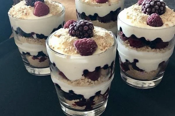 Käsekuchen-Dessert im Glas mit frischen Früchten und Sahne