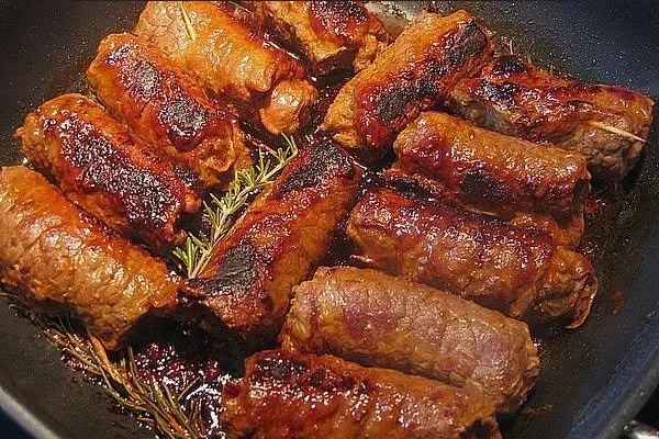 Mini-Rouladen gefüllt mit Pesto und Schinken, serviert mit Oliven-Rotwein-Sauce