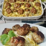 Nudeln mit Pilzsauce und Fleischbällchen auf einem Teller serviert.