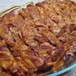 Räuberbraten mit frischen Kräutern und Beilagen auf einem Teller angerichtet.