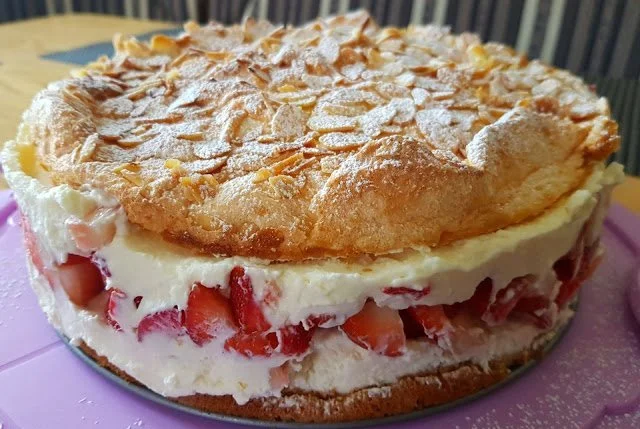 Schneemousse-Erdbeertorte mit frischen Erdbeeren und dekorativer Sahne