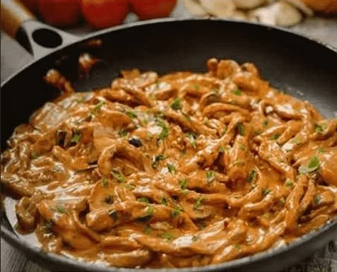 Schnitzelstreifen in cremiger Senfsahnesauce serviert auf einem Teller