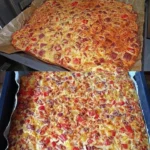 Leckere Schüttelpizza auf einem Teller, garniert mit frischen Zutaten.