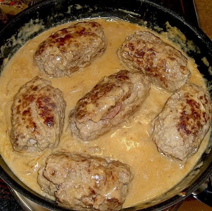 Schwarzwälder Hackrouladen serviert auf einem Teller mit Beilagen