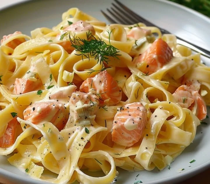 Tagliatelle mit Lachs und frischen Kräutern auf einem Teller