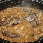 Wildschweinbraten mit Waldpilzen auf einem rustikalen Holzbrett serviert