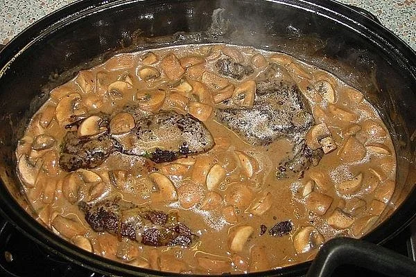 Wildschweinbraten mit Waldpilzen auf einem rustikalen Holzbrett serviert