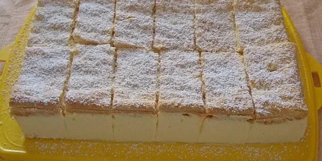 Zitronen Mascarpone-Schnitten auf einem Teller dekoriert mit frischen Zitronen.